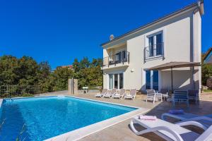 a villa with a swimming pool next to a house at Faszinierende Villa mit traumhaften Meerblick zur Insel Krk mit Privatpool, Tischtennis, Billard, Grill in Šmrika