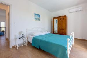 a bedroom with a bed with a blue bedspread at Faszinierende Villa mit traumhaften Meerblick zur Insel Krk mit Privatpool, Tischtennis, Billard, Grill in Šmrika +32 photos