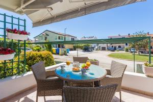 ein Tisch und Stühle auf einem Balkon mit Getränken in der Unterkunft Lichtdurchflutetes Apartment nur 500 Meter zum Strand mit privater Terrasse in Funtana