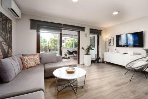 un soggiorno con un divano e un tavolo di Exquisites Ferienhaus mit privatem Garten, Liegen, Kinderstuhl, Waschmaschine - nur 700 Meter zum Strand a Poreč (Parenzo)