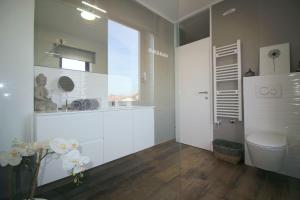 bagno bianco con servizi igienici e finestra di Exquisites Ferienhaus mit privatem Garten, Liegen, Kinderstuhl, Waschmaschine - nur 700 Meter zum Strand a Poreč (Parenzo) Altre 26 foto