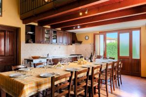 a kitchen with a large wooden table with chairs at Faszinierendes Ferienhaus mit Privatpool, Volleyballfeld, Fussballplatz, Trampolin beim bekannten Radweg Parenzana in Vižinada