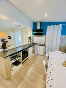 a kitchen with a counter and a table with chairs at Lily House in Sainte-Marie