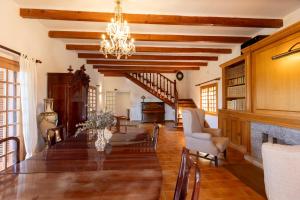 a dining room with a long table and a chandelier at Villa Rosa, espaciosa casa con piscina in Marratxí 