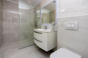 un bagno bianco con lavandino e doccia di Modernes Apartment direkt am Strand mit Whirlpool, Meerblick, Lounge-Bereich a Dramalj Altre 29 foto