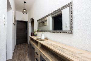 德拉马利Beeindruckendes Apartment mit Whirlpool, Lounge-Liegen, Meerblick, Grill的墙上有水槽和镜子的浴室 更多32张照片