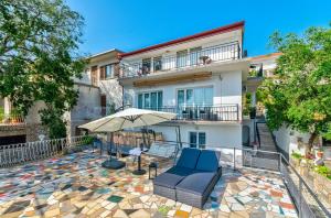 德拉马利Beeindruckendes Apartment mit Whirlpool, Lounge-Liegen, Meerblick, Grill的一座带椅子和遮阳伞的庭院