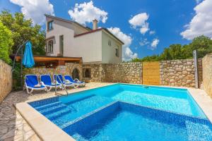 une piscine devant une maison dans l'établissement Ruhiges Apartment mit Holzkohlegrill, Pool mit Whirlpoolfunktion, Waschmaschine, Trockner, à Grižane