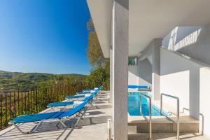a row of blue lounge chairs next to a swimming pool at Modernes Apartment mit Panoramablick, Pool - inmitten von historischem Zentrum in Pazin