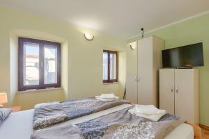 a bedroom with a large bed with a television on it at Modernes Apartment mit Panoramablick, Pool - inmitten von historischem Zentrum in Pazin