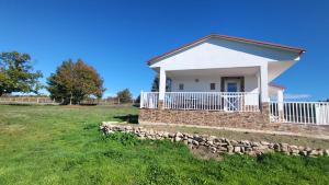a white house with a stone wall in a field at “Casa abella “ in Monterrei