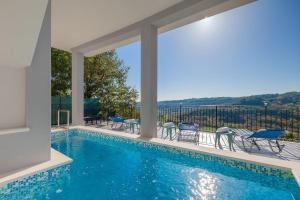 a swimming pool with a view of a house at Modernes Apartment mit traumhafter Aussicht, Pool, Privatparkplatz, WiFi in Pazin