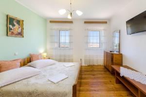 a bedroom with a bed and a flat screen tv at Mediterranes Steinhaus mit grosser Terrasse, Aussendusche, Privatpool, Babybett, Waschmaschine in Grižane