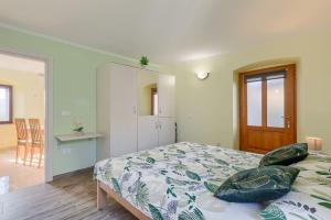 a bedroom with a bed and a table and a desk at Mediterranes Apartment mit Panoramablick, Pool, Privatparkplatz, Grill in Pazin