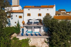 a large white house with chairs and a swimming pool at Mediterranes Apartment mit Panoramablick, Pool, Privatparkplatz, Grill in Pazin +32 photos