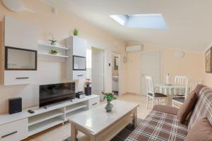 a living room with a couch and a tv at Beeindruckendes Apartment mit Panoramablick, Pool, Privatparkplatz, Grill in Pazin