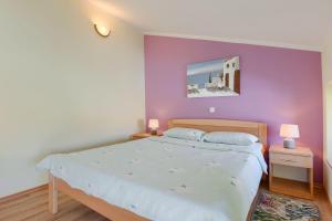 a bedroom with a bed and a purple wall at Beeindruckendes Apartment mit Panoramablick, Pool, Privatparkplatz, Grill in Pazin +27 photos