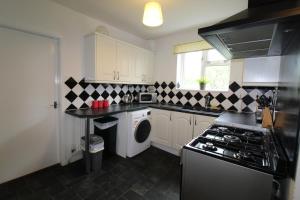 Una cocina con lavadora y secadora. en Byron House, en Chesterfield