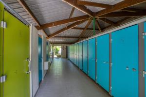 un couloir de casiers verts et bleus dans un couloir scolaire dans l'établissement Camping du Lac de Grolejac, à Groléjac