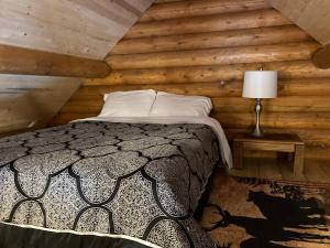 a bedroom with a bed in a log cabin at Lofted log cabin with fire table in Kelowna