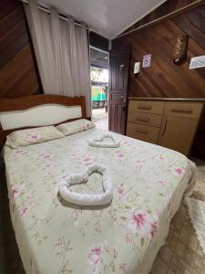 Un dormitorio con una cama con un corazón hecho de flores en Pousada Coração da Ilha, en Ilha do Mel