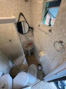 Un baño con inodoro, lavabo y espejo. en Pousada Coração da Ilha, en Ilha do Mel