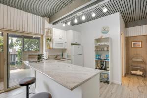 Una cocina con gabinetes blancos y una isla grande. en Cozy Honolulu Retreat with Pool Access, Near Beaches, en Waimanalo