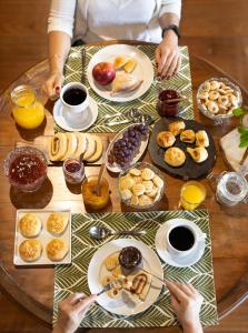 a table with plates of breakfast foods on it at Pousada Armazém 26 in Tiradentes