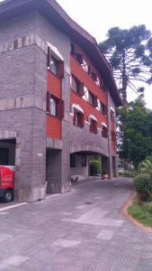 a building with a parking lot in front of it at Flat Gramado Alpen in Gramado