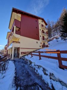 a building in the snow next to a fence at Centre Station - La Vallée Blanche 2 - La Foux in Allos