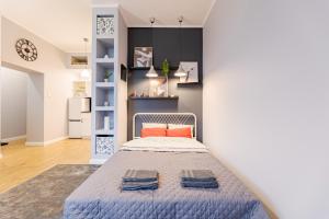 a bedroom with a bed with blue sheets and orange pillows at Time Apartment,Parking,Wi-Fi in Łódź