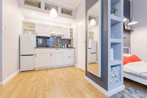 a kitchen with white cabinets and a large mirror at Time Apartment,Parking,Wi-Fi in Łódź +20 photos