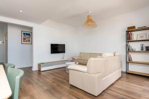ein Wohnzimmer mit Sofa und Fernseher in der Unterkunft Costa 014 in Almada