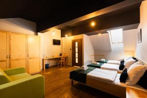 a bedroom with two beds and a couch in it at Dwór Kolesin in Nowe Kramsko