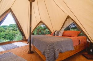 a bedroom in a tent with a bed in it at Eco Luxe Glamping Tent - King Bed at Holos in Barú +25 photos