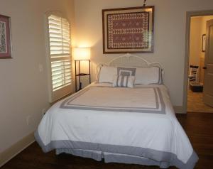 une chambre avec un grand lit avec des draps blancs dans l'établissement The Wimberley House, à Wimberley