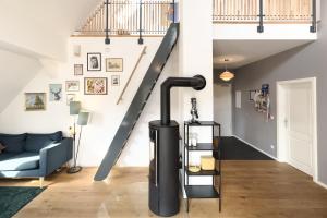 une cheminée dans un salon avec un escalier dans l'établissement Altes Backhaus Haselberg, à Haselberg