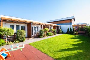 a yard with a house and a playground at Sunrise-Sarbinowo domki i apartamenty in Sarbinowo