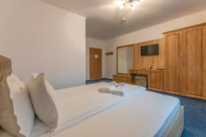 een slaapkamer met een groot bed met twee handdoeken erop bij Pensiunea Lara in Rîşnov