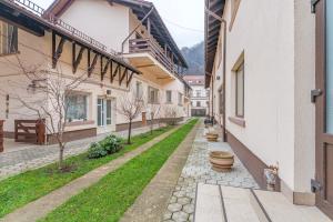 een loopbrug tussen twee gebouwen met een tuin bij Pensiunea Lara in Rîşnov