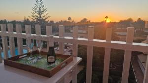 a bottle of champagne and two wine glasses on a fence at Sunset Apartment in Playa del Ingles