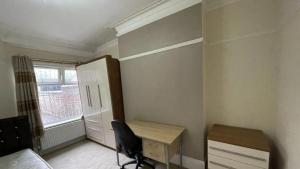 a bedroom with a desk and a bed and a window at Comfy and cosy 1 bed flat in IG11 in Barking