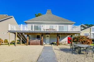 a house with a deck and a table and chairs at Private Dock, Hot Tub Waterfront Ocean Pines Home in Ocean Pines