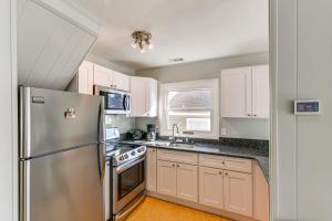 a kitchen with white cabinets and a stainless steel refrigerator at Private Dock, Hot Tub Waterfront Ocean Pines Home in Ocean Pines