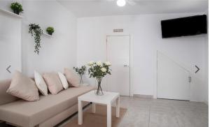 エステポナにあるApartamento Céntrico en Esteponaのソファと花瓶が置かれた白いリビングルーム +4枚の写真