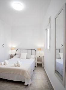 エステポナにあるApartamento Céntrico en Esteponaの白いベッドルーム(ベッド2台、鏡付)