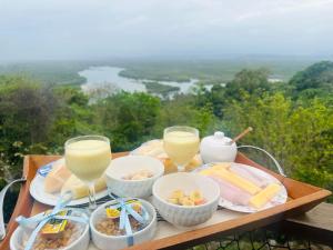a tray of food with wine glasses and bowls of food at Minas Em Marambaia in Rio de Janeiro