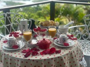 a table with a white table cloth with breakfast foods and orange juice at Minas Em Marambaia in Rio de Janeiro