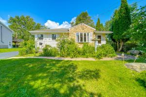 a house with a green lawn in front of it at Mayville Getaway with Deck Near Chautauqua Lake! in Mayville