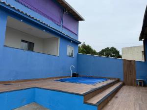 サン・ペドロ・ダ・アルデイアにあるCasa Azul 4 quartosのウッドデッキとスイミングプール付きの青い建物